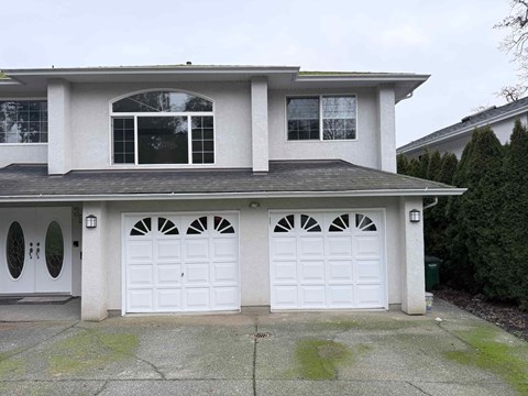A two-story house with a white garage door.