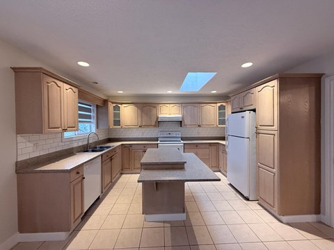 A kitchen with wooden cabinets and a white refrigerator.