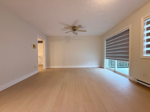 A room with a ceiling fan and wooden flooring.