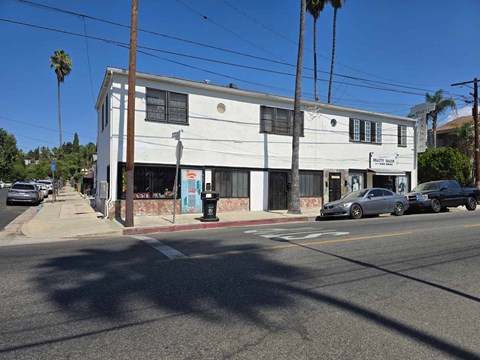 A white building with a blue door and windows on the side.