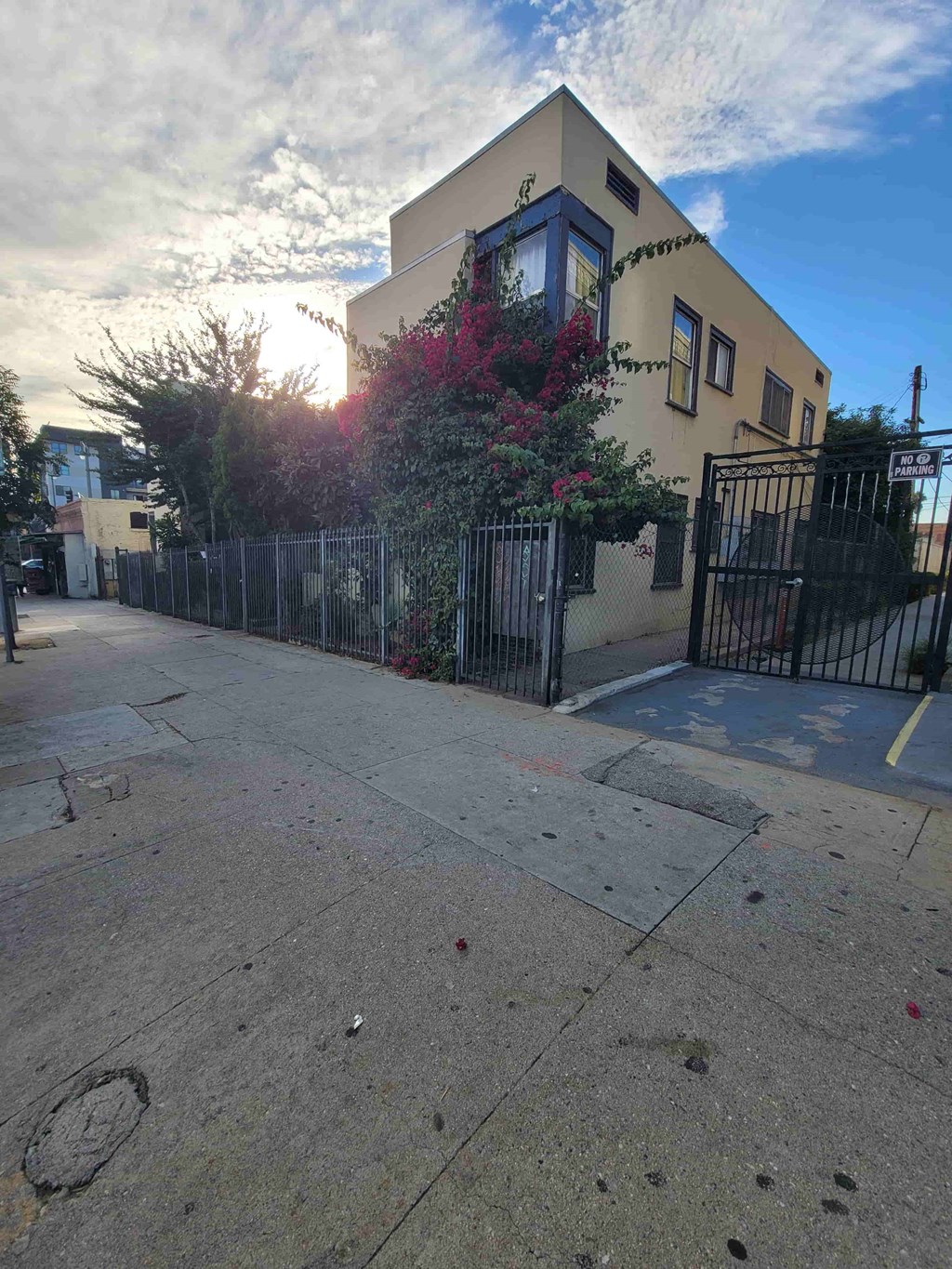 A yellow house with a black gate in front.