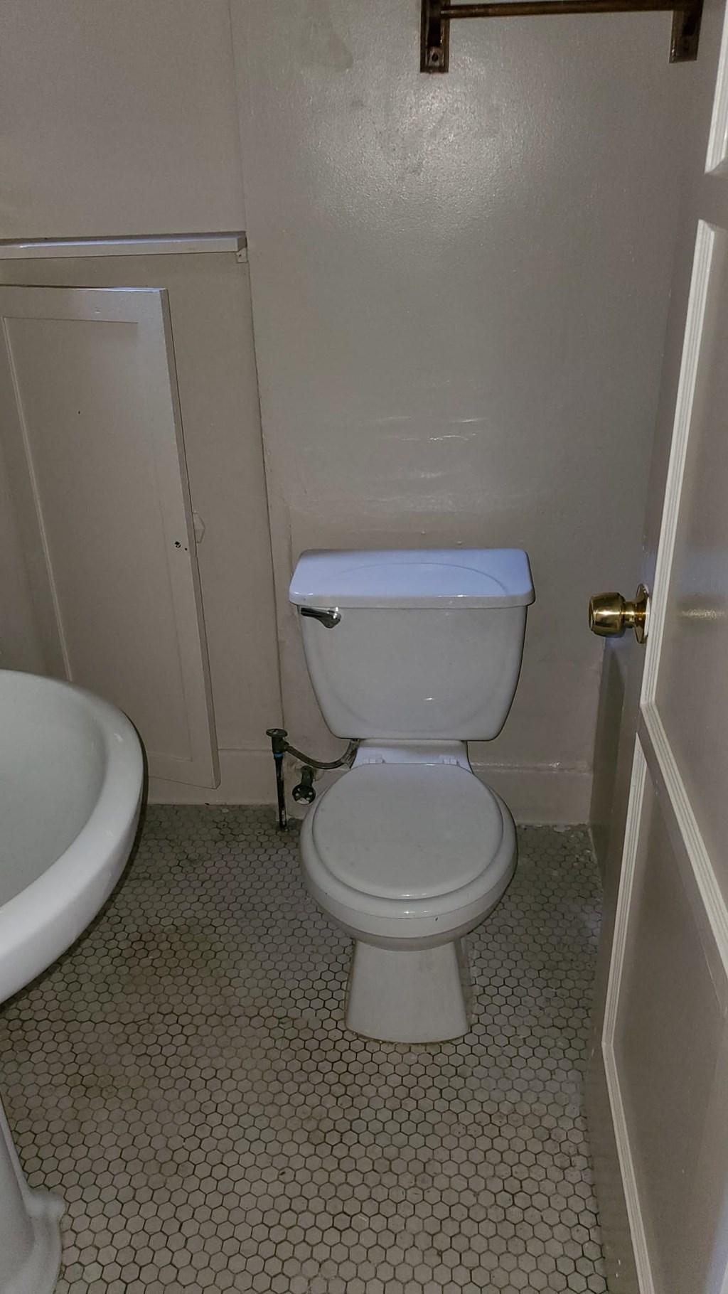A white toilet in a bathroom with a white sink.