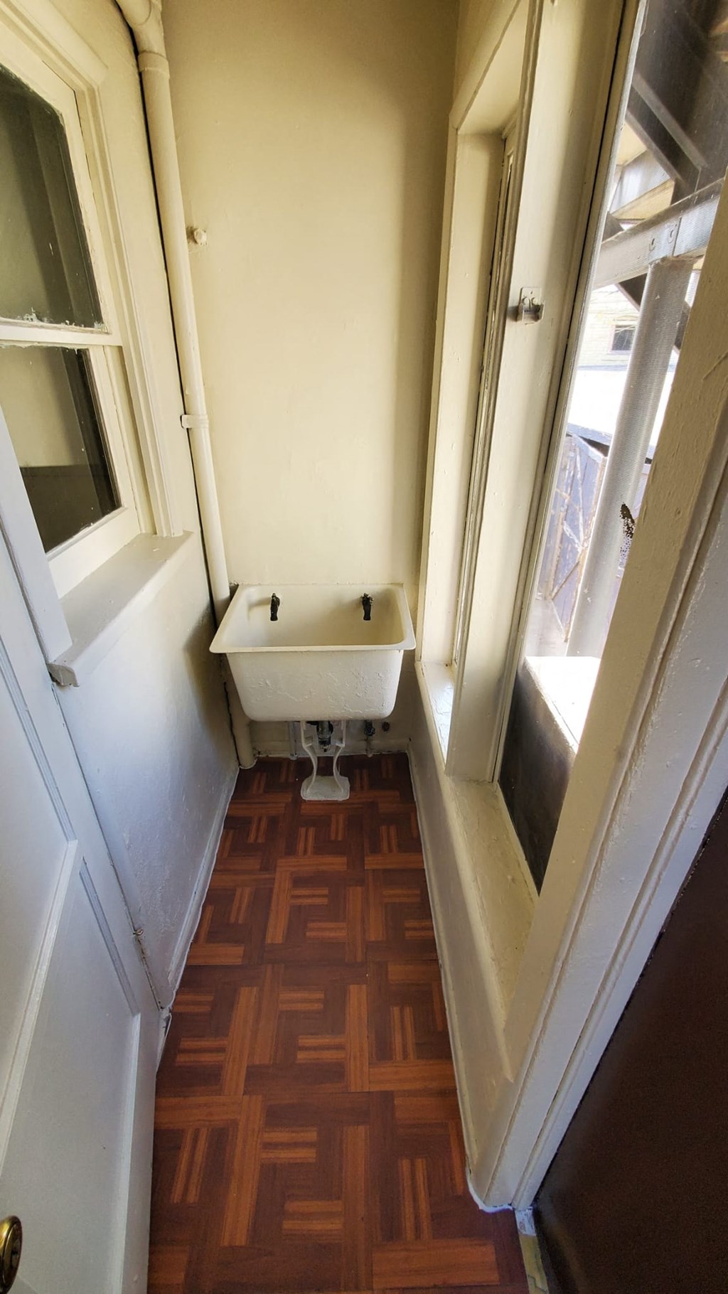 A small white toilet in a narrow space between two walls.