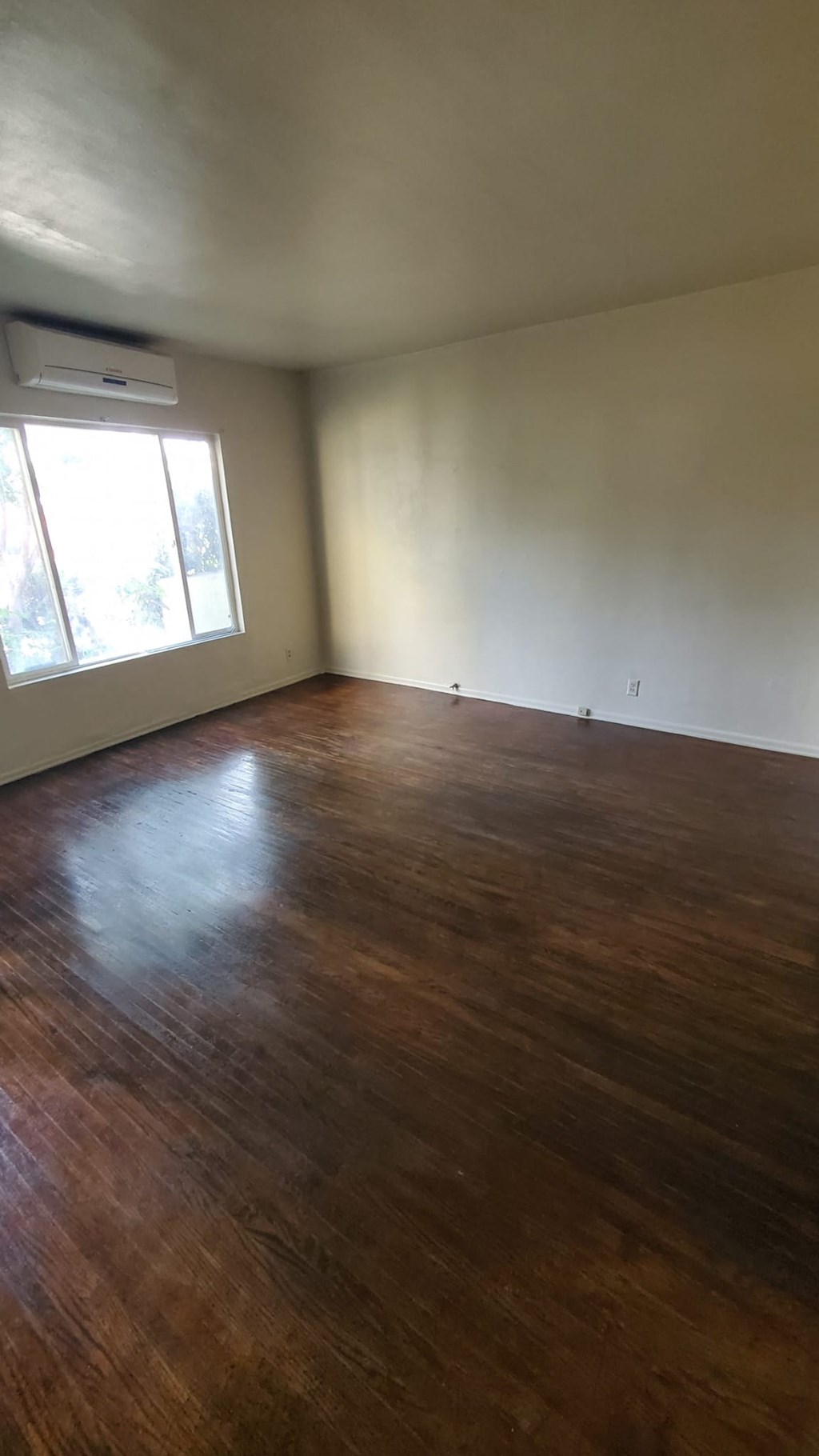 A room with wooden floors and a window.