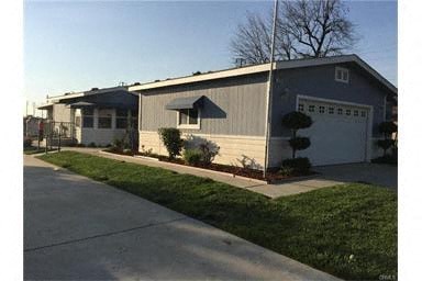 A house with a grey roof and a white garage door.