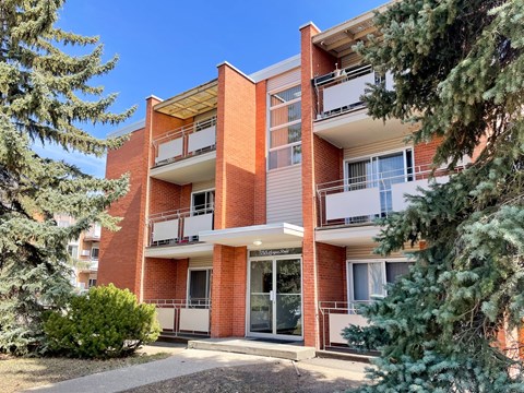 A red brick apartment building with a balcony on the second floor.