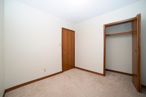 A room with a brown door and a white wall.