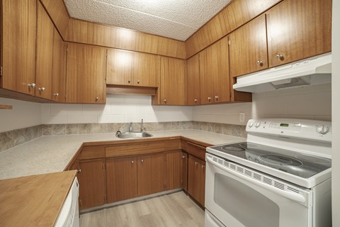 A kitchen with wooden cabinets and a white oven.