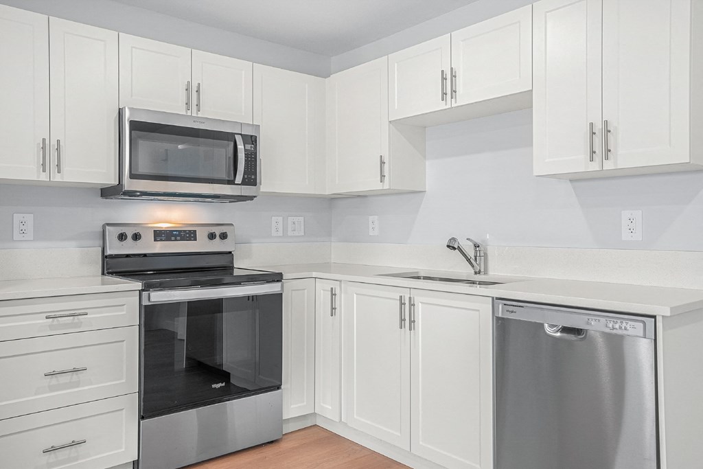 a kitchen with white cabinets and stainless steel appliances