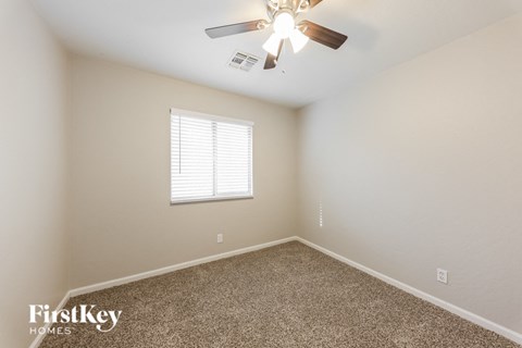 a bedroom with a ceiling fan and a window