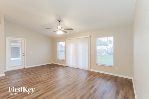 a living room with wood flooring and a ceiling fan