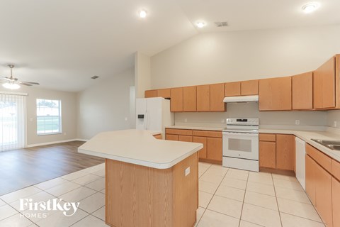 a large kitchen with wooden cabinets and a white counter top