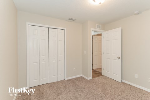 a bedroom with two closets and a door to a hallway