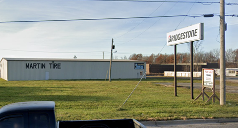 a sign for the tree store in front of a field