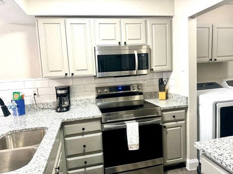a kitchen with stainless steel appliances and white cabinets