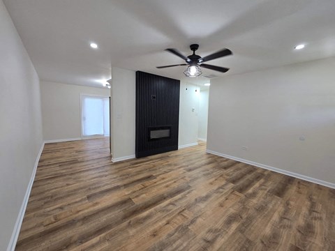 a living room with a ceiling fan and a door
