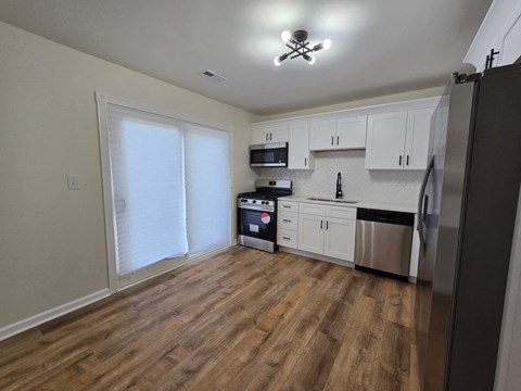 a kitchen with white cabinets and stainless steel appliances