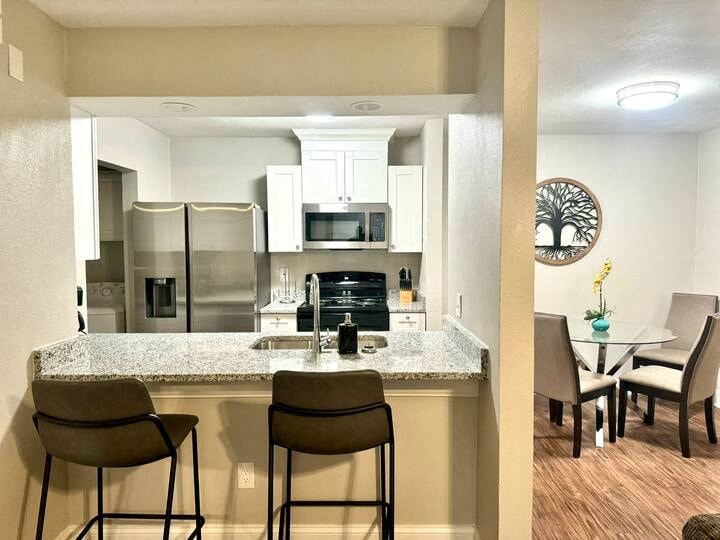 a kitchen with a bar and chairs and a table