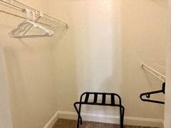 a empty closet with a chair and two empty shelves