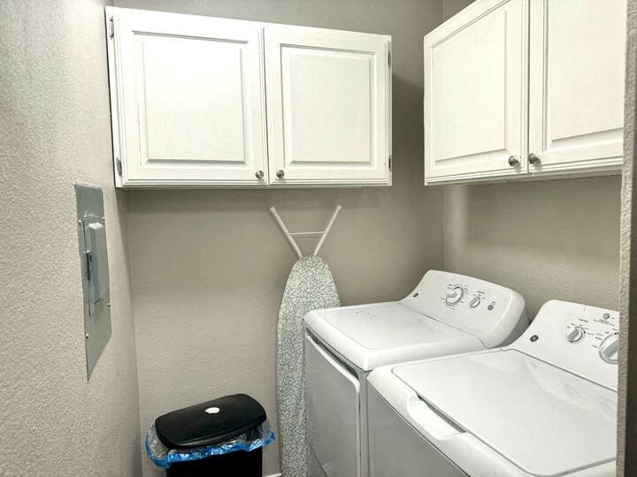 a small laundry room with white cabinets and white appliances
