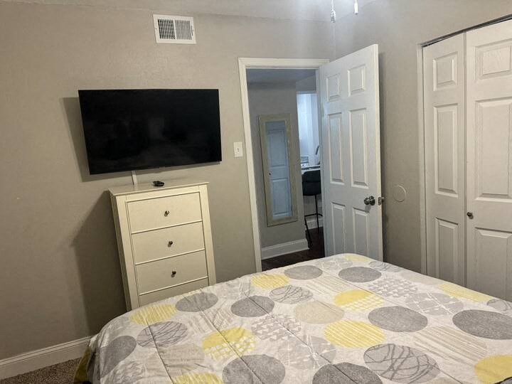 a bedroom with a bed and a television on the wall