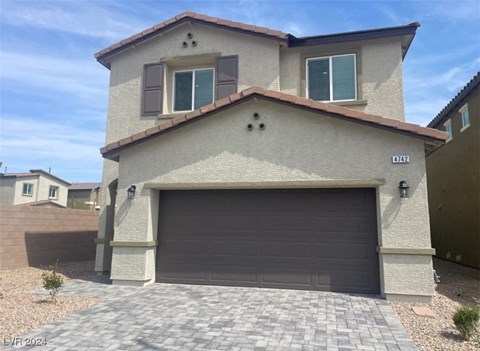 A house with a garage door and a driveway in front.