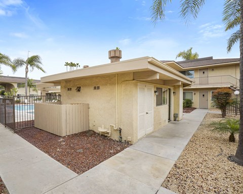 A house with a beige exterior and a brown roof with a chimney.