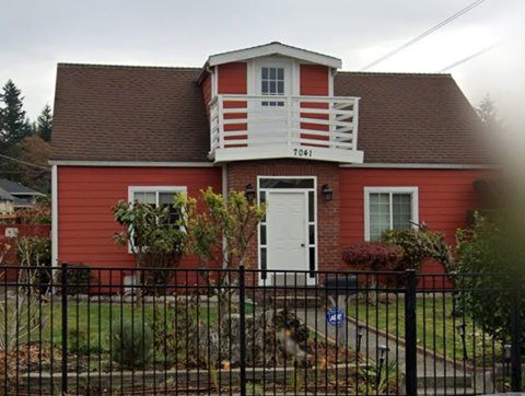 a red house with a white balcony on top of it