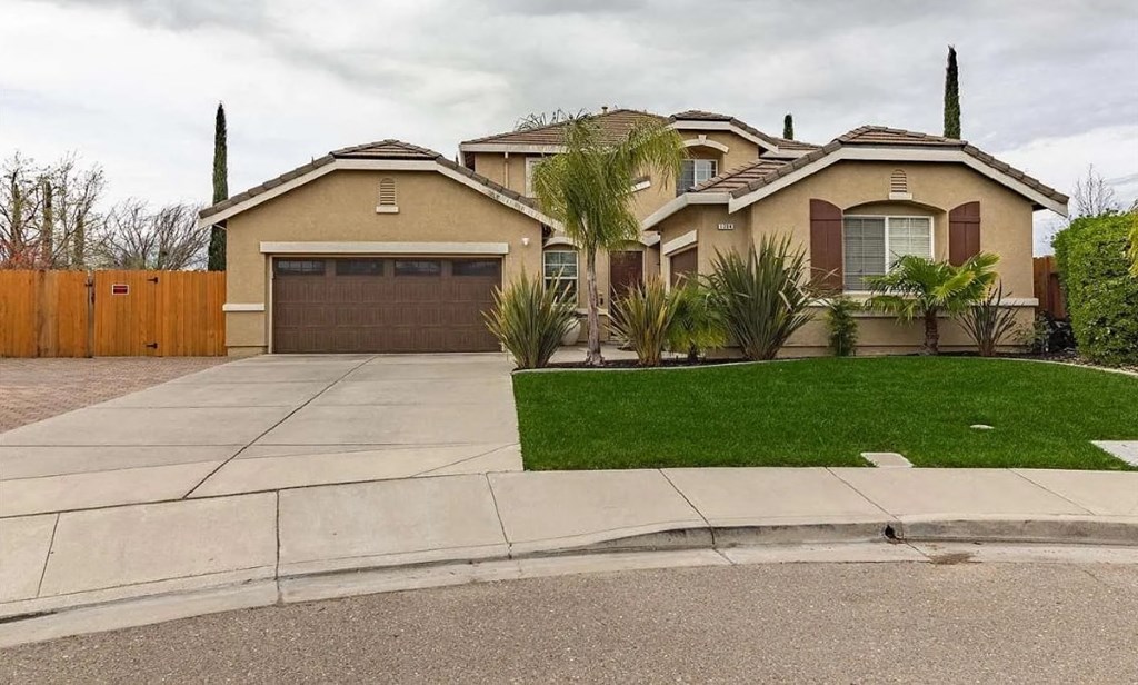 a house with a driveway and lawn in front of it