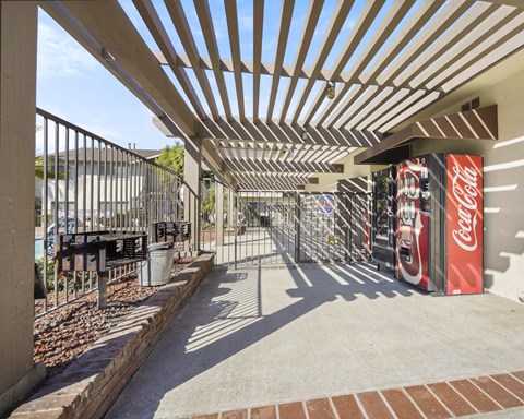 A Coca Cola vending machine is on the right side of a covered walkway.