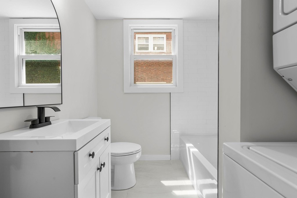 A white bathroom with a toilet, sink, and bathtub.