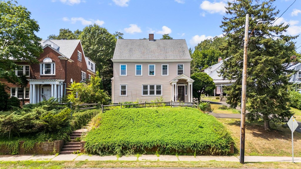 A house with a green lawn in front of it.