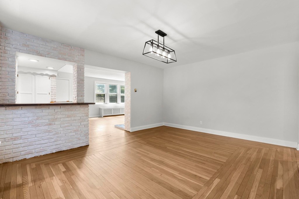A room with wooden floors and a brick wall.