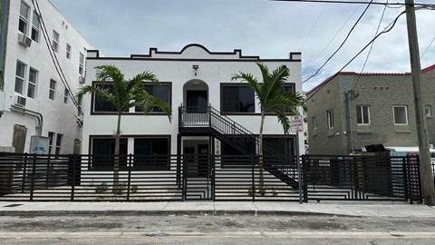 A white building with a black staircase in front.