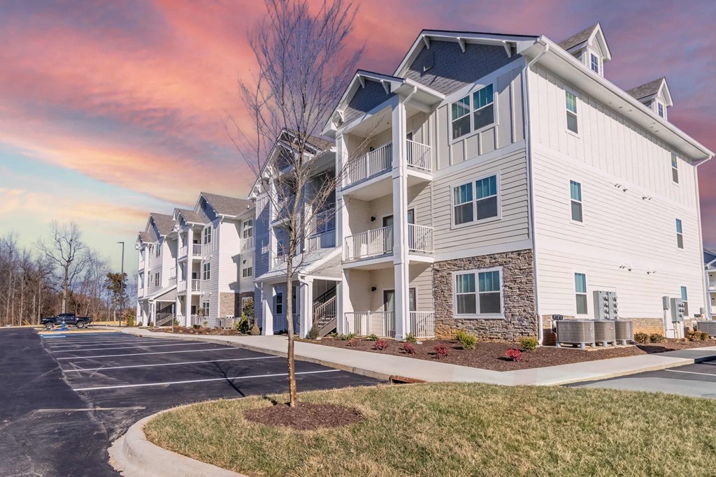 a street view of an apartment building with a cloudy sky