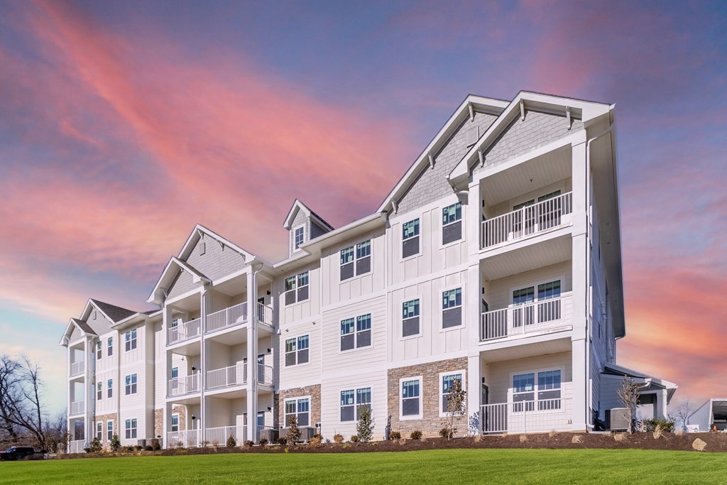 an exterior view of an apartment building at sunset