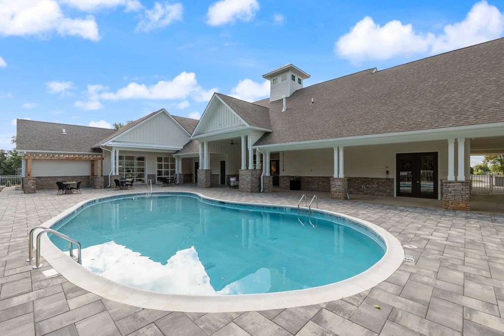 a swimming pool in front of a house with a pool