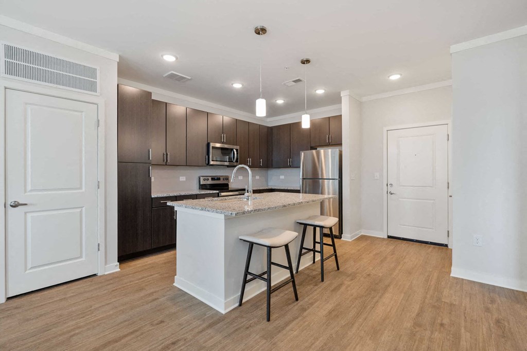 a kitchen with a large island with bar stools