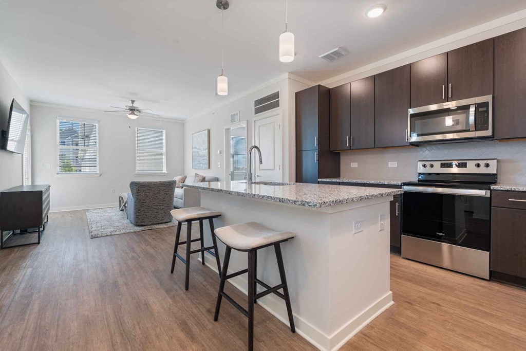 a kitchen with an island and stools in front of a counter top