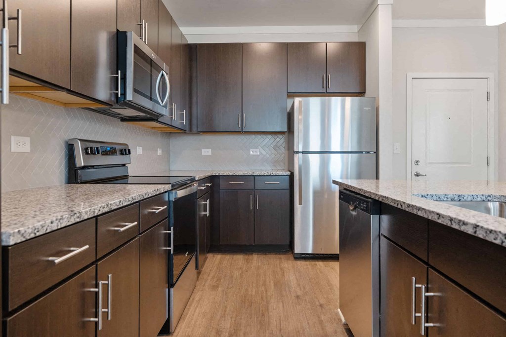 a large kitchen with stainless steel appliances and marble counter tops