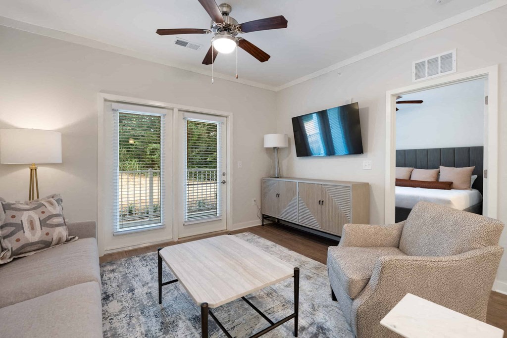 a living room with a couch and a table and a ceiling fan