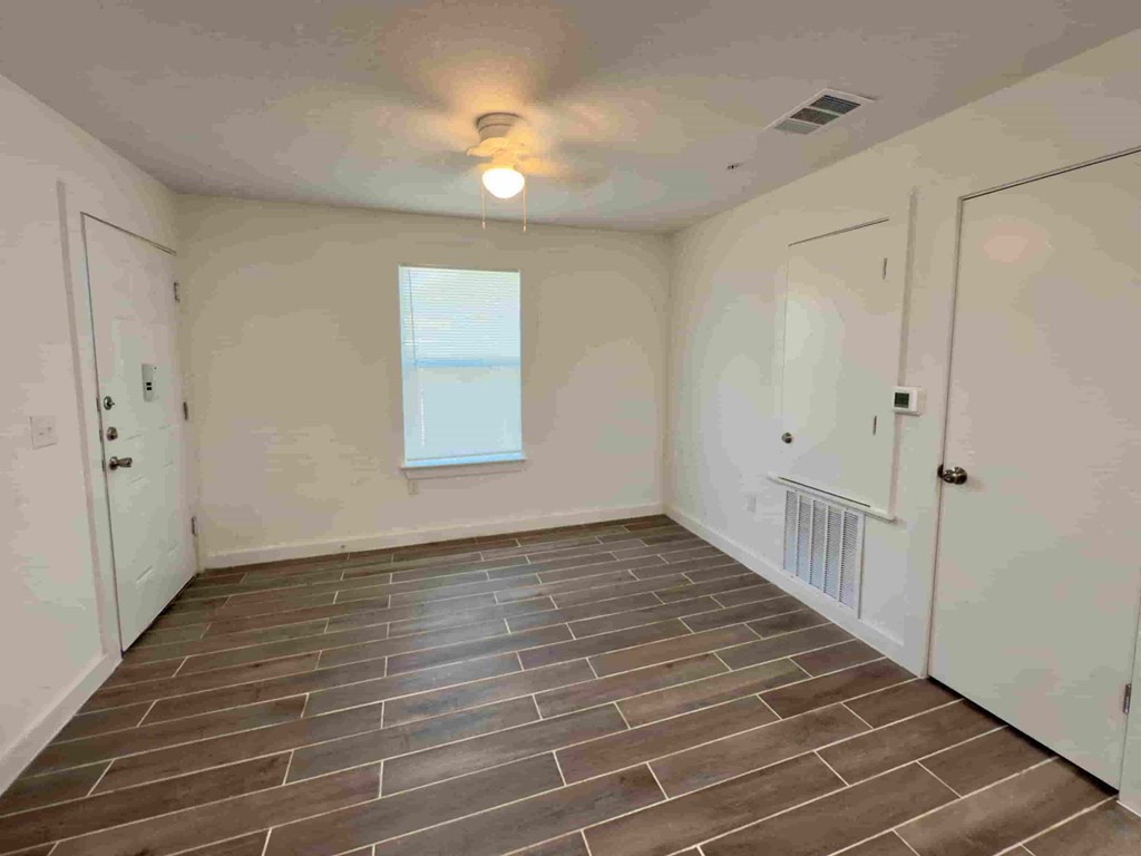 a large empty room with tile flooring and a door