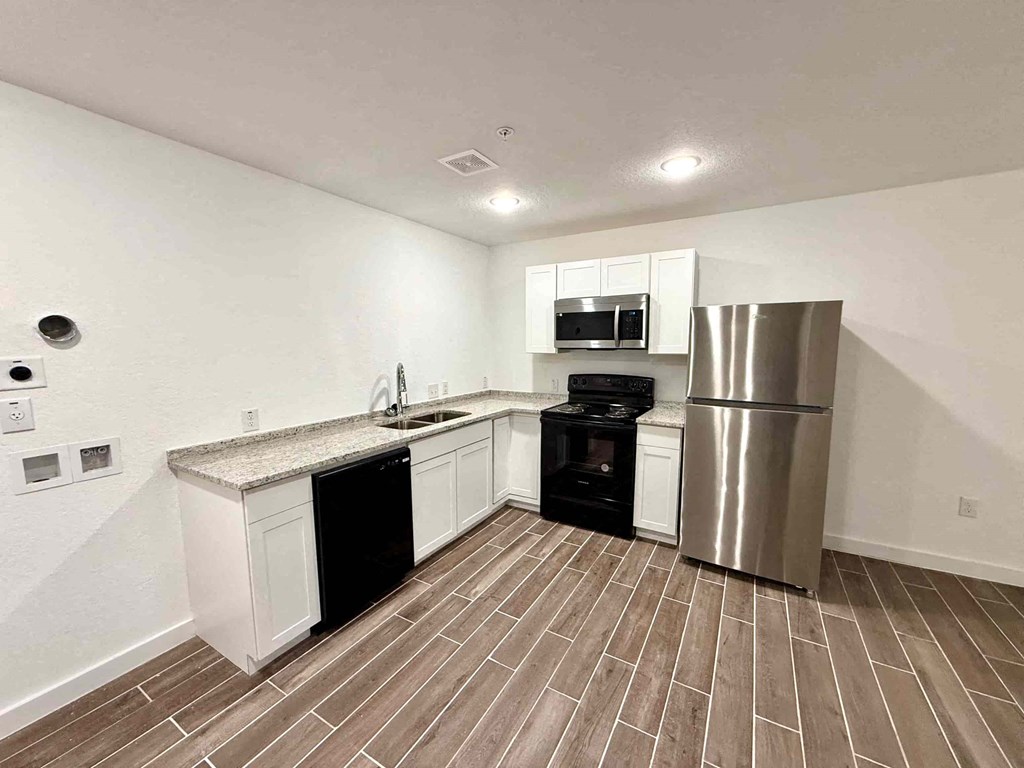 a kitchen with a stainless steel refrigerator and a sink