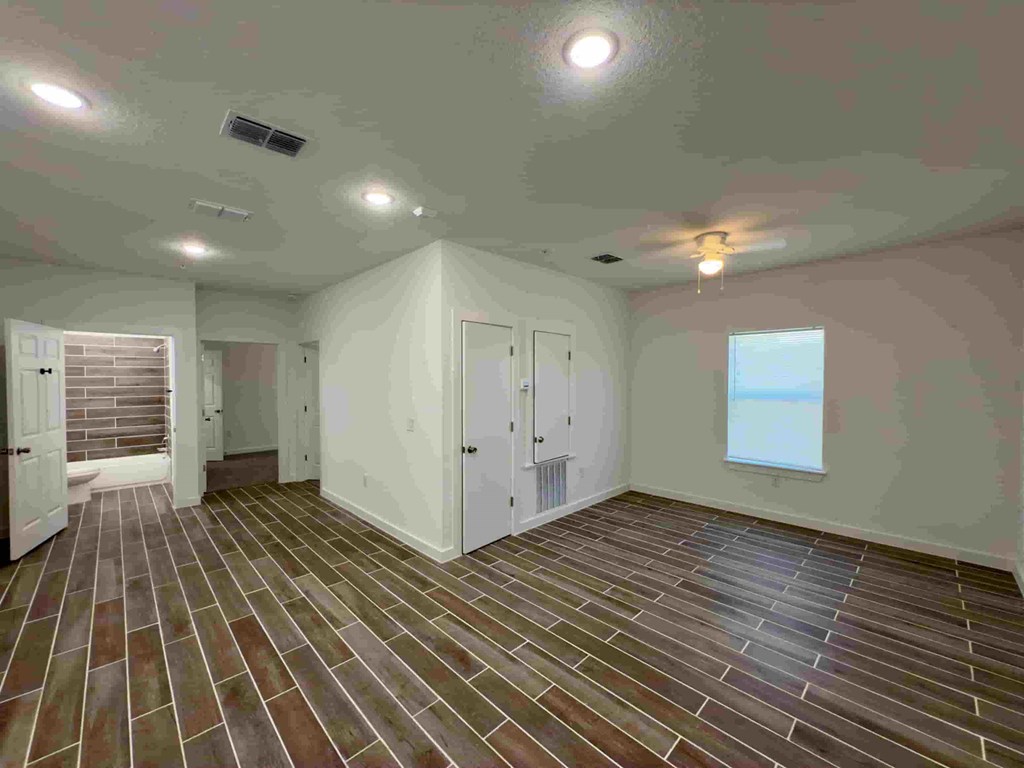 a remodeled living room with wooden floors and white walls