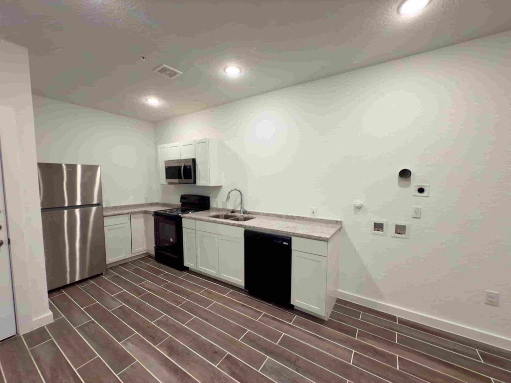 a kitchen with a stainless steel refrigerator and a sink