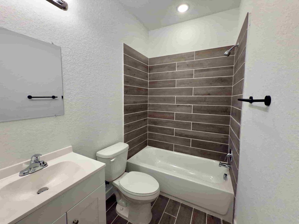 a bathroom with a toilet and a tub and a sink