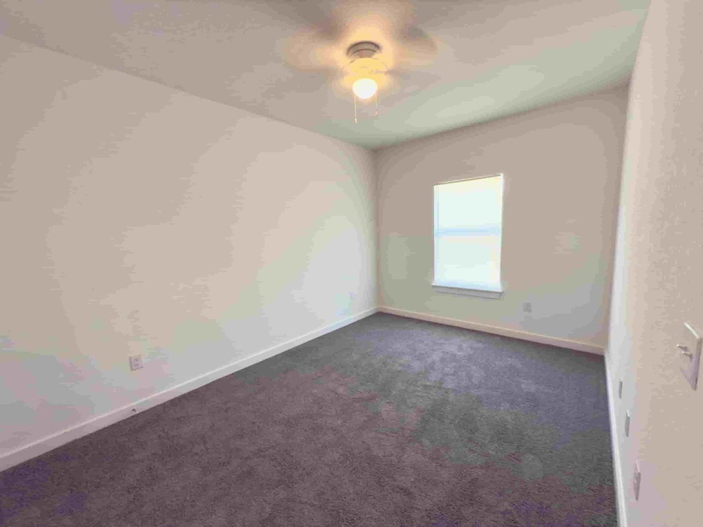 an empty room with white walls and a window