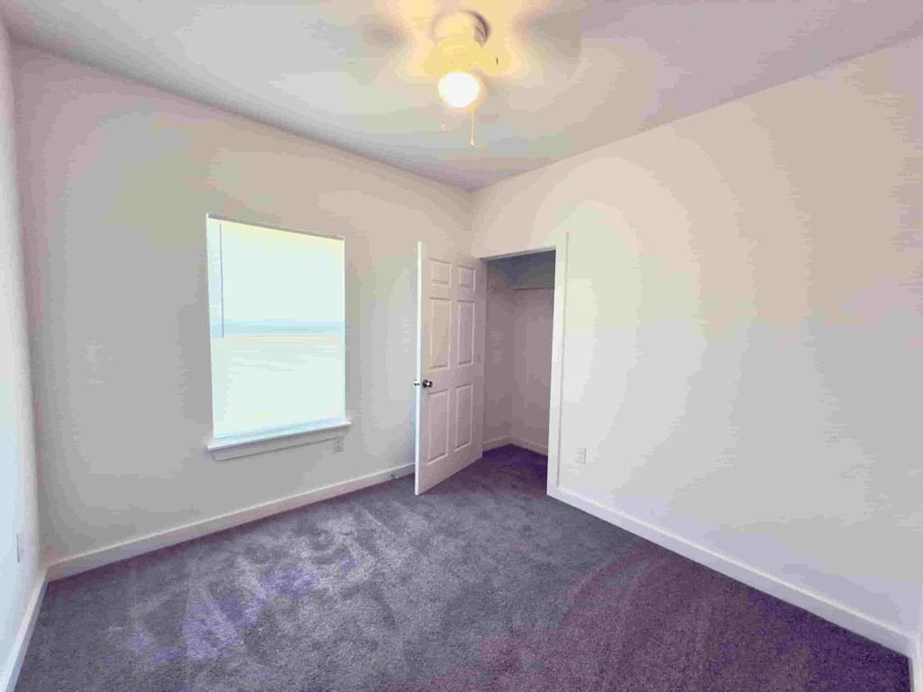 an empty room with white walls and a window