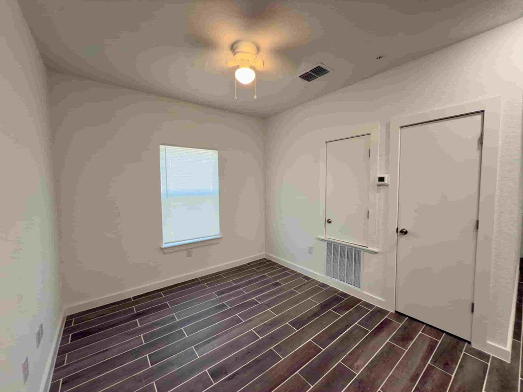 a empty room with a door and a ceiling fan