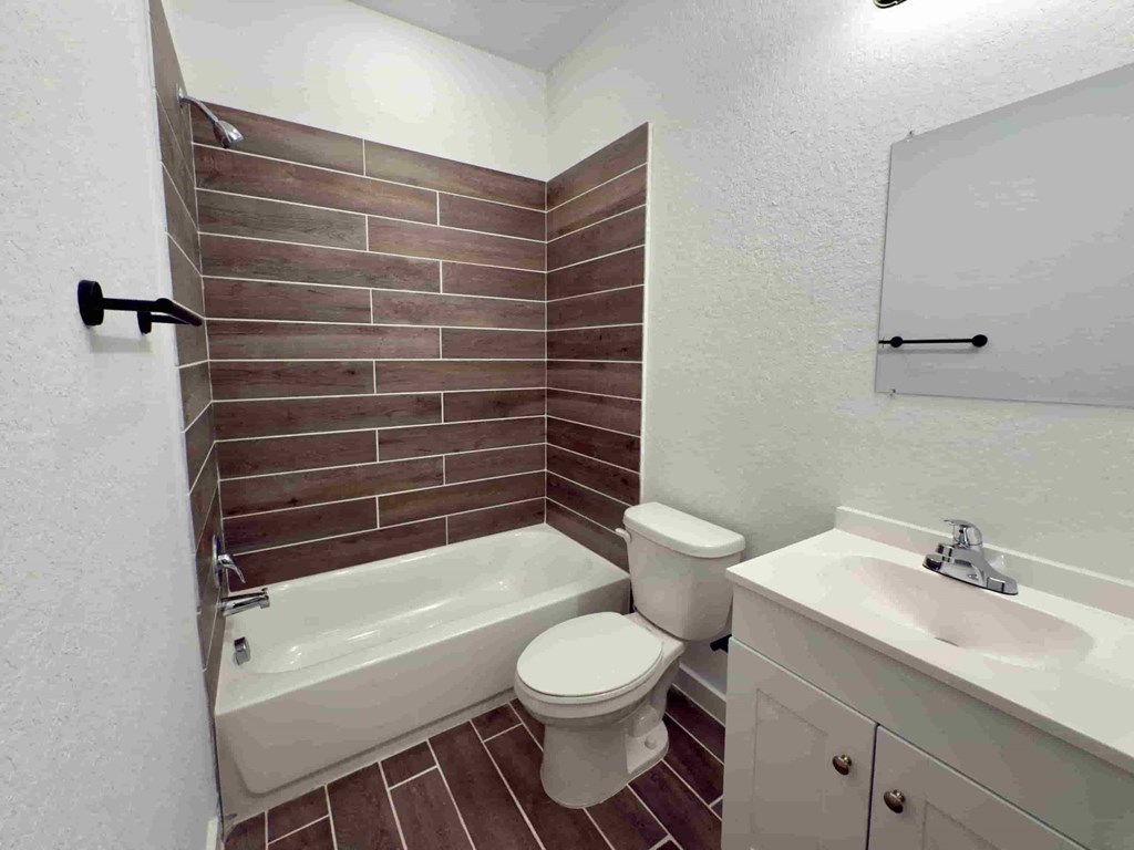 a bathroom with a toilet and a tub and a sink